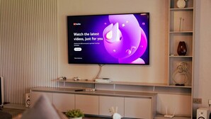 Televisor de pantalla plana penjat a la paret amb la interfície de YouTube.