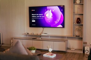 Ein Flachbildfernseher an der Wand mit angezeigter YouTube-Oberfläche.