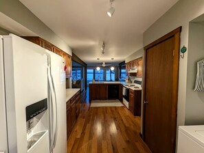 A modern kitchen with wooden cabinets, a refrigerator, and a dishwasher.