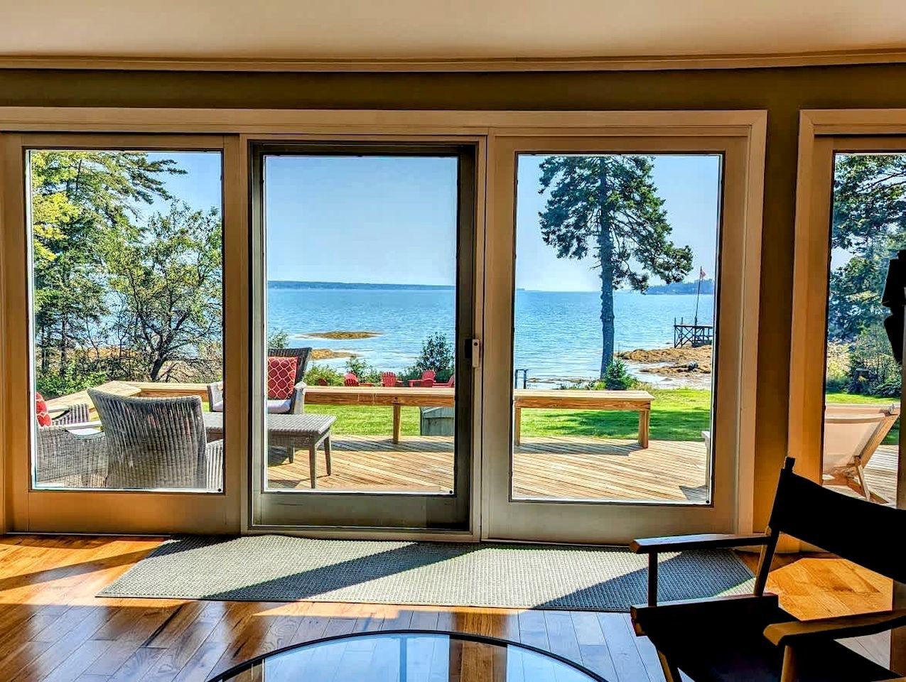 Una habitación con un gran ventanal corredero que da a una terraza exterior con vistas al mar.