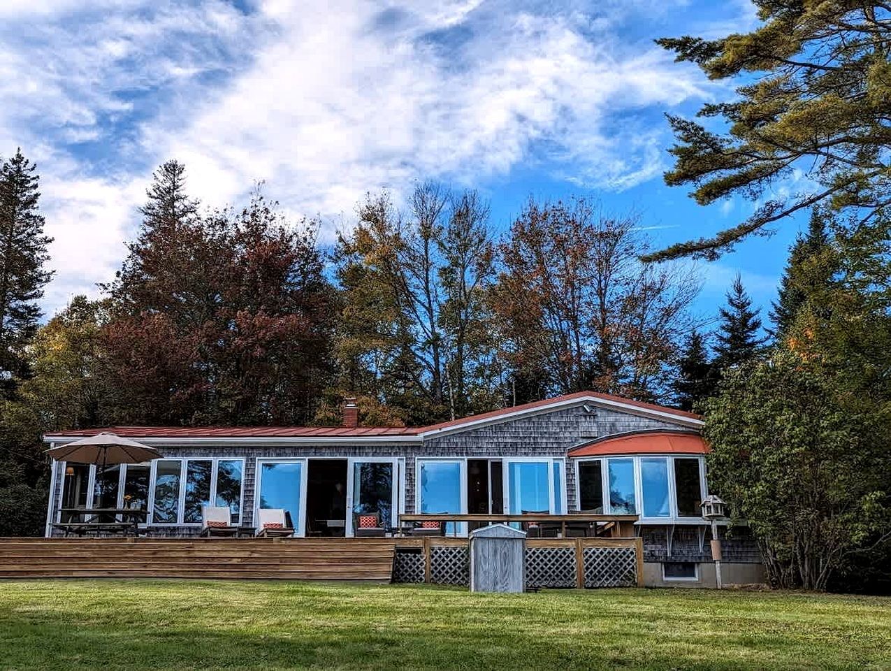 Una casa a due piani con un portico coperto e un cortile recintato.