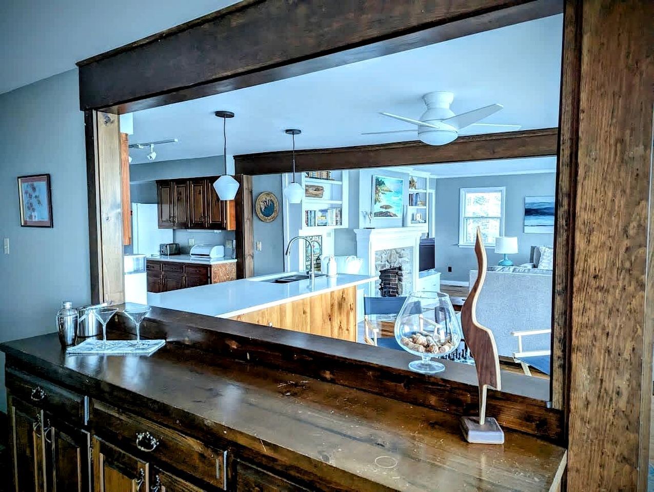 Una cocina con encimera de madera, isla con cubierta de vidrio y una escultura decorativa de un pájaro.