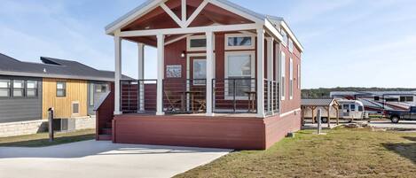 A small, single-story building with a covered porch, a fire escape, and a visible fire safety sign.