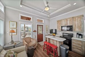 A modern kitchen with a central island, wooden cabinets, and a built-in microwave. - Cozy Tiny Home Retreat with Pool and Resort Access Near Fredericksburg, TX (Fredericksburg)