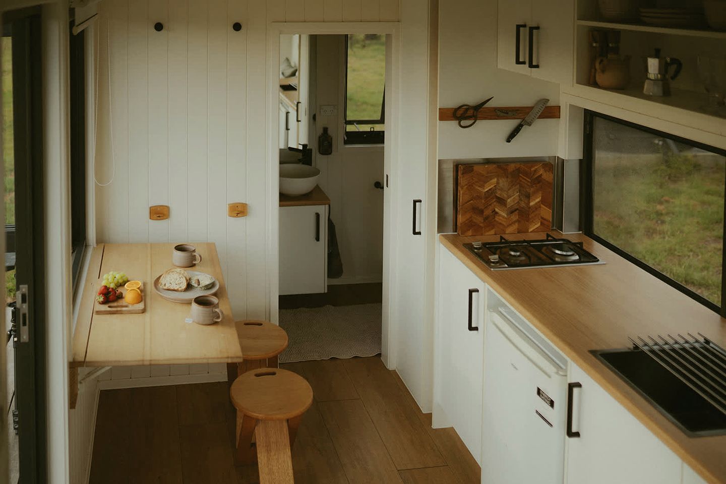 Une cuisine de taille réduite, dotée d’un plan de travail en bois, d’une cuisinière et d’une fenêtre.