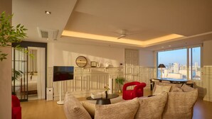 A modern living room with a sofa, a red chair, a TV, and a fireplace. - Black Ban (Seoul)