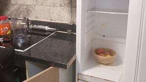 A kitchen with a blender, a wooden cabinet, and a white refrigerator. - Beautiful 2-bedroom apartment in London perfect for your stay (London)