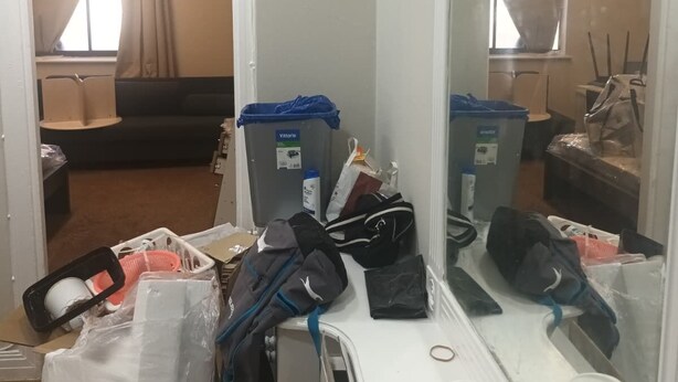 A cluttered room with a large mirror, a trash bin, and a coffee cup. - Beautiful 2-bedroom apartment in London perfect for your stay (London)