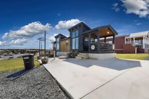 A modern building with a patio area, outdoor seating, and a view of the sky. - Boutique Tiny Home Getaway with Resort-Style Amenities Near Fredericksburg, TX (Fredericksburg)