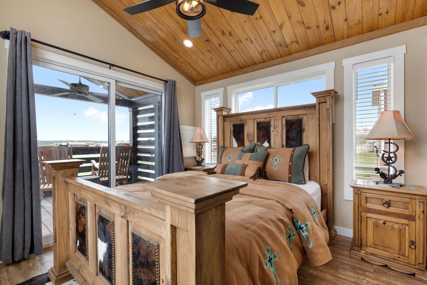 Quarto com cama, mesa de cabeceira, abajur e vista para o exterior.