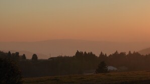 A landscape with a field, trees, and distant hills. - A peaceful mountain chalet at an elevation of 800 meters (Sapois)