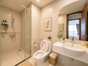 Ein modernes Badezimmer mit einer Duschkabine, Toilette, Waschbecken und einem Spiegel.