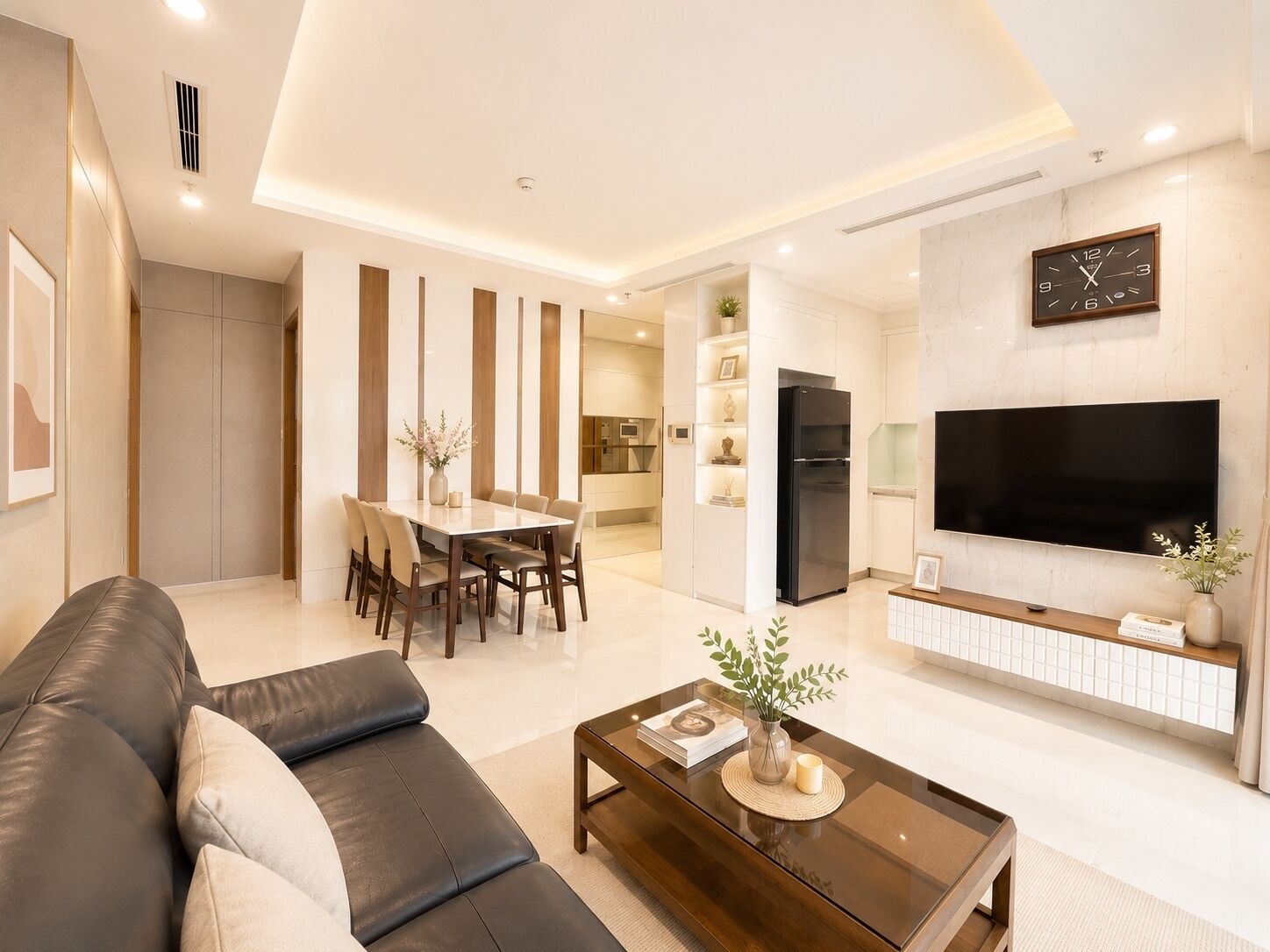 Ein modernes Wohnzimmer mit Sofa, Couchtisch, Fernseher und Essbereich.