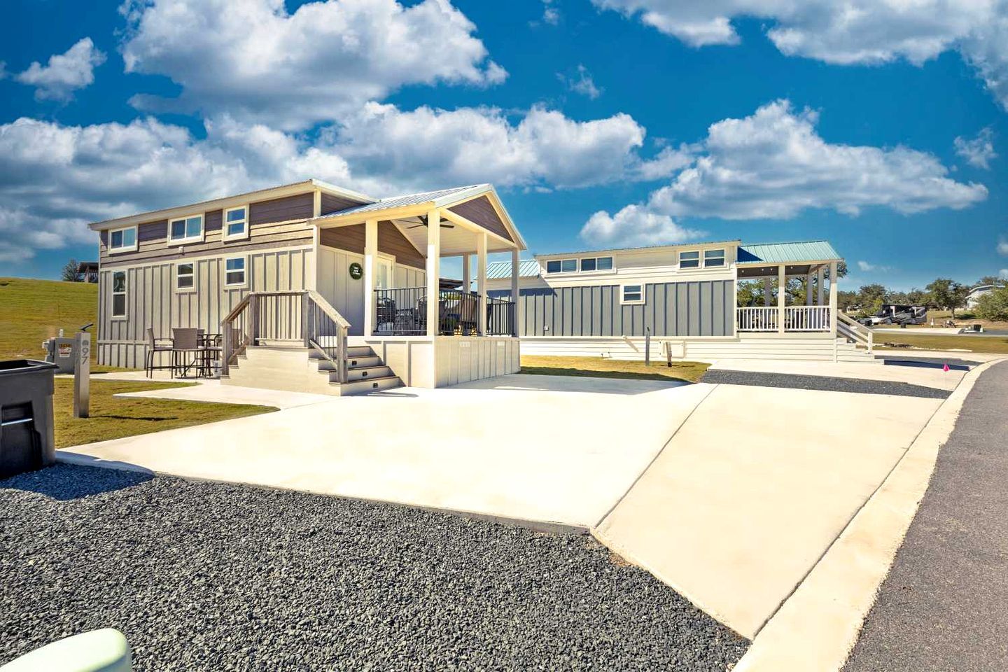 A modern two-story building with a covered outdoor seating area and a small pavilion.