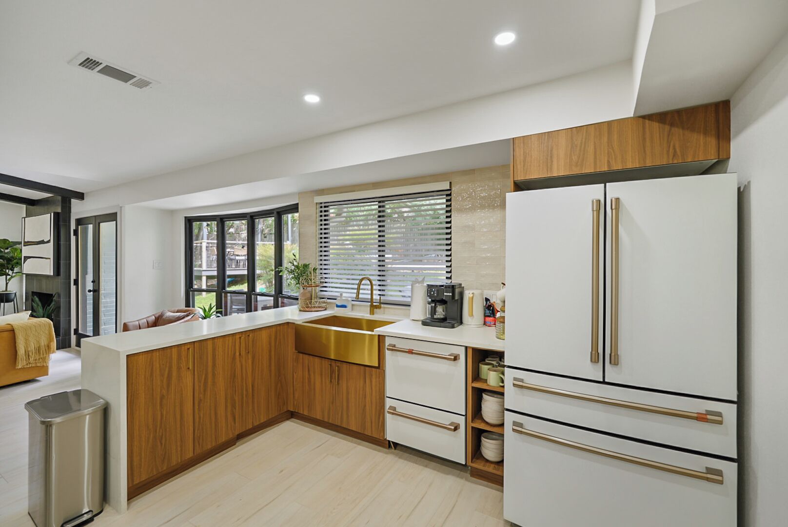 Una cocina moderna con una isla central, electrodomésticos de acero inoxidable y vistas al exterior.