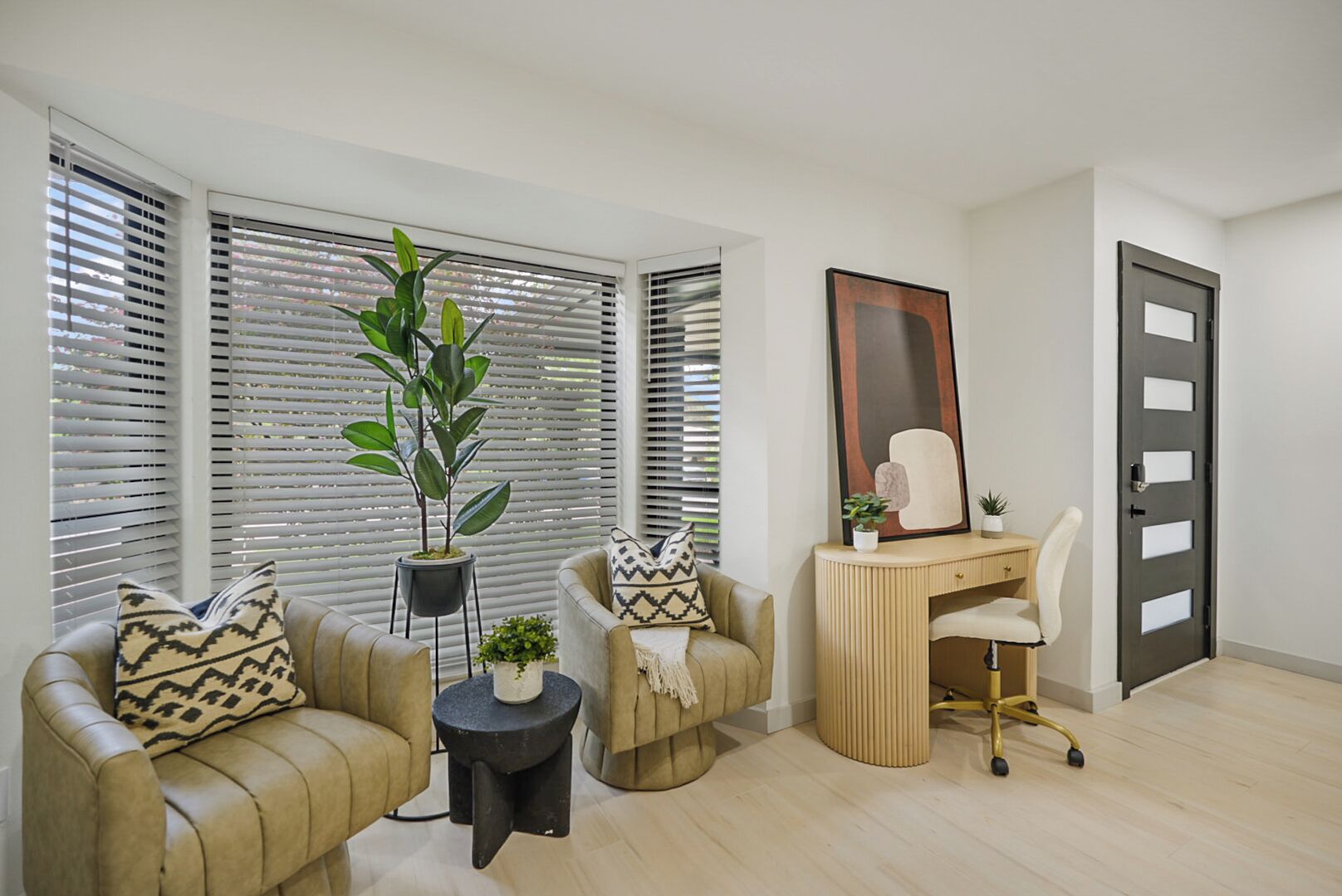 Una sala de estar moderna con un sofá, un escritorio y una planta en maceta.