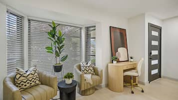 Una sala de estar moderna con un sofá, un escritorio y una planta en maceta.