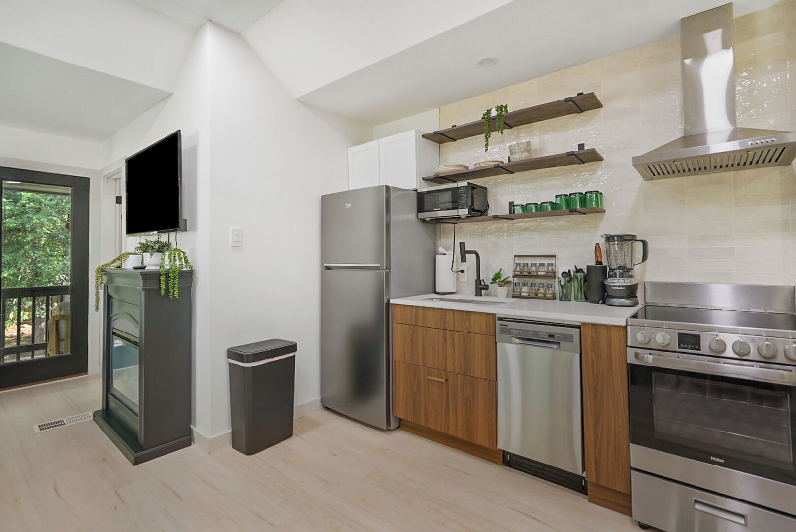 Eine moderne Küche mit Edelstahlgeräten, Holzschränken und einem eingebauten Backofen.