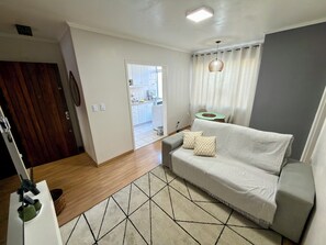 Ein Wohnzimmer mit einer Couch, einem Couchtisch und einem gemusterten Teppich.