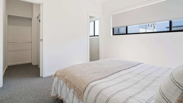 Ein Schlafzimmer mit Bett, Fenster und Schrank.