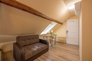 Habitación cuádruple, vista al jardín | Área de sala de estar