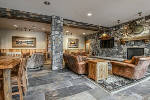 A rustic interior with stone walls, leather furniture, and a fireplace. - Walk to Gondola | Rare 4br in River Run, Hot Tub (Keystone)