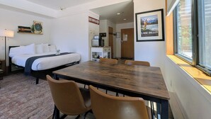 A hotel room with a bed, a dining table with chairs, a chandelier, a framed picture, and a window with a view. - New Listing | Updated | Walk to Slopes (Keystone)