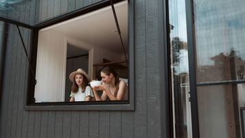 Ein Fenster, durch das zwei Personen zu sehen sind, wobei eine davon eine Schüssel hält.