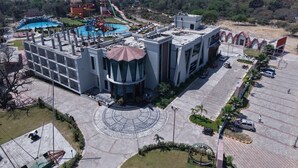 A large building with a central dome, a swimming pool, and a water park. - MARINO WATERPARK AND RESORT (Bakshi Ka Talab)