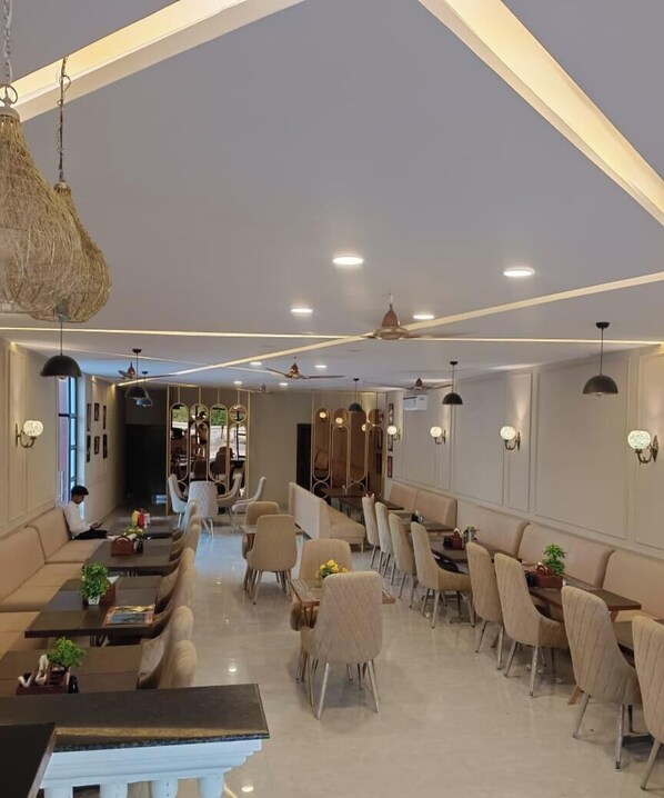A modern hotel lobby with seating areas, a reception desk, and a staircase. - MARINO WATERPARK AND RESORT (Bakshi Ka Talab)
