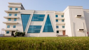 A modern building with a flat roof, multiple windows, and a symmetrical facade. - MARINO WATERPARK AND RESORT (Bakshi Ka Talab)
