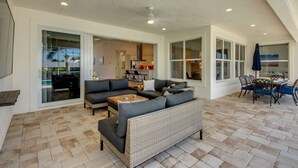 Amplia sala de estar con sofá, mesa de centro y muebles de mimbre.