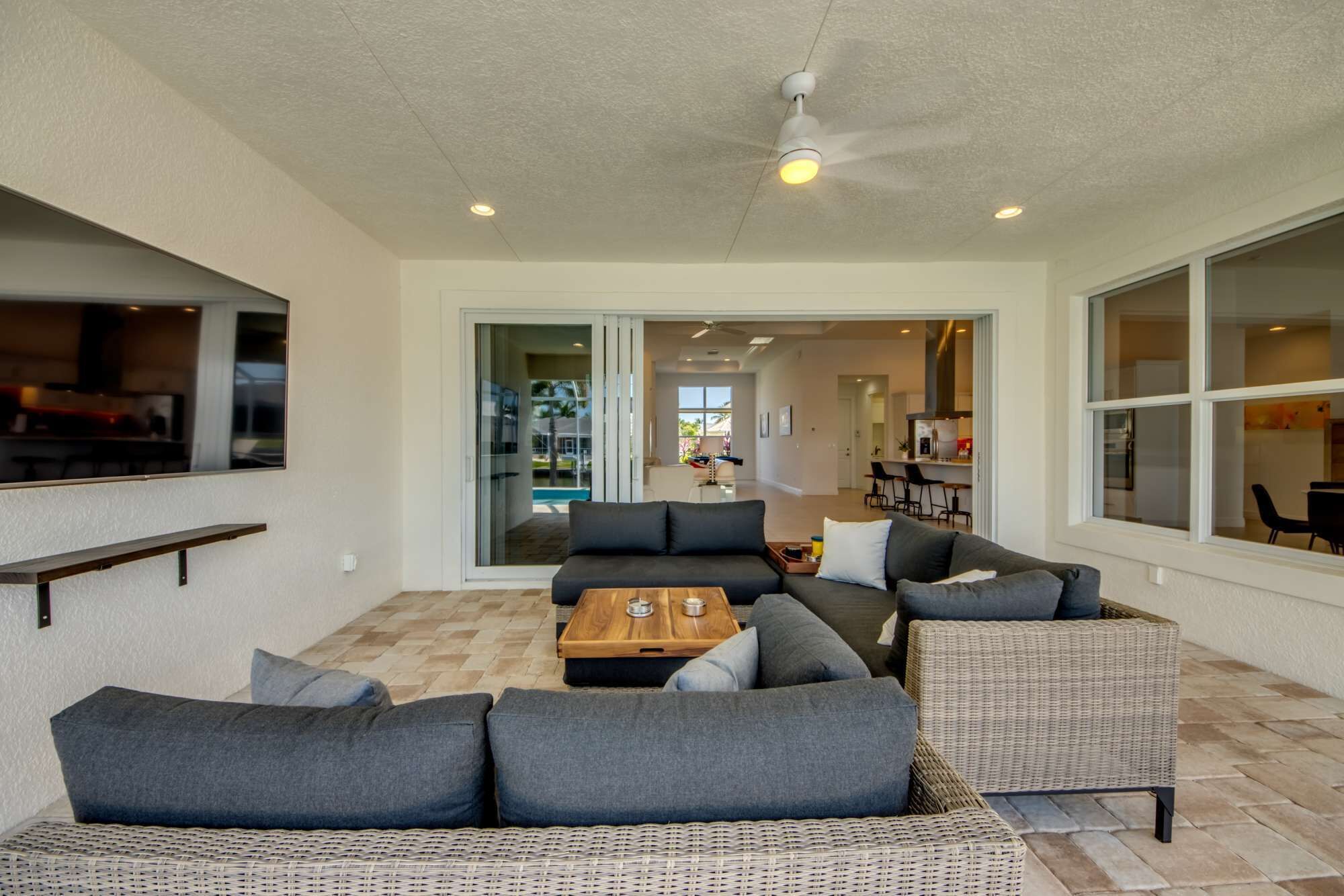 A modern living room with a sofa set, a coffee table, and a wicker chair.