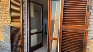 A building entrance with a glass door and wooden shutters. - Luce, Penthouse with Panoramic Terrace (Assisi)