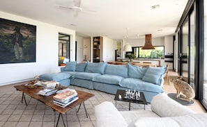 A modern living room with a sectional sofa, a coffee table, and a fireplace.