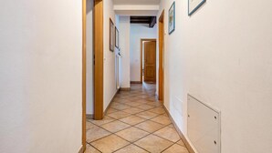 A hallway with tiled flooring, wooden doors, and framed pictures on the walls. - Castle 'Historic Chateau Soldà Dolomites' with Mountain View, Private Garden and Wi-Fi (Vigo di Fassa)