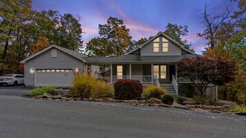 A two-story house with a garage, a front porch, and a driveway.