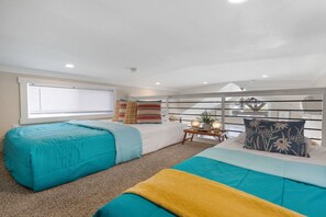 A hotel room with two beds, a small table with decorative items, a window with blinds, and a ceiling with recessed lighting. - Hill Country Tiny Home Retreat with Resort Amenities Near Fredericksburg, TX (Fredericksburg)