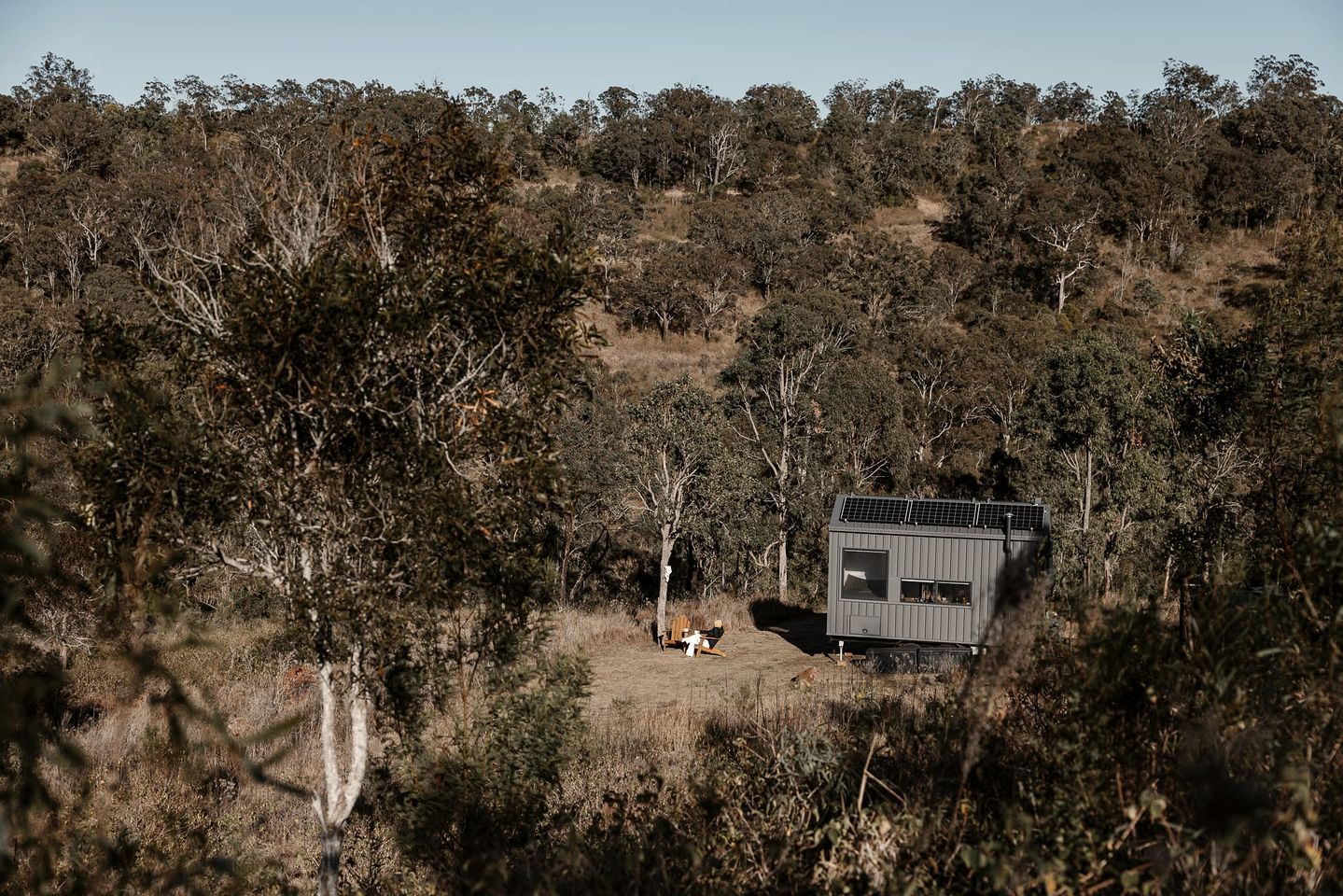Un chalet isolé, entouré d’une forêt dense, offrant une vue dégagée sur le paysage naturel environnant.