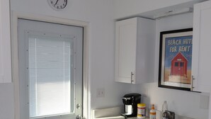 A small, clean kitchen with white cabinets, a coffee maker, and a sink. - 2-Min Walk to Beach · 1BR Duplex w/ Private Lot (Redington Shores)