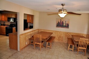 A dining area with wooden furniture and a ceiling fan. - Spacious Lakefront Home with Beach Access and Sports Courts for Fun-Filled stays in Buchanan Dam, Texas (Buchanan Dam)