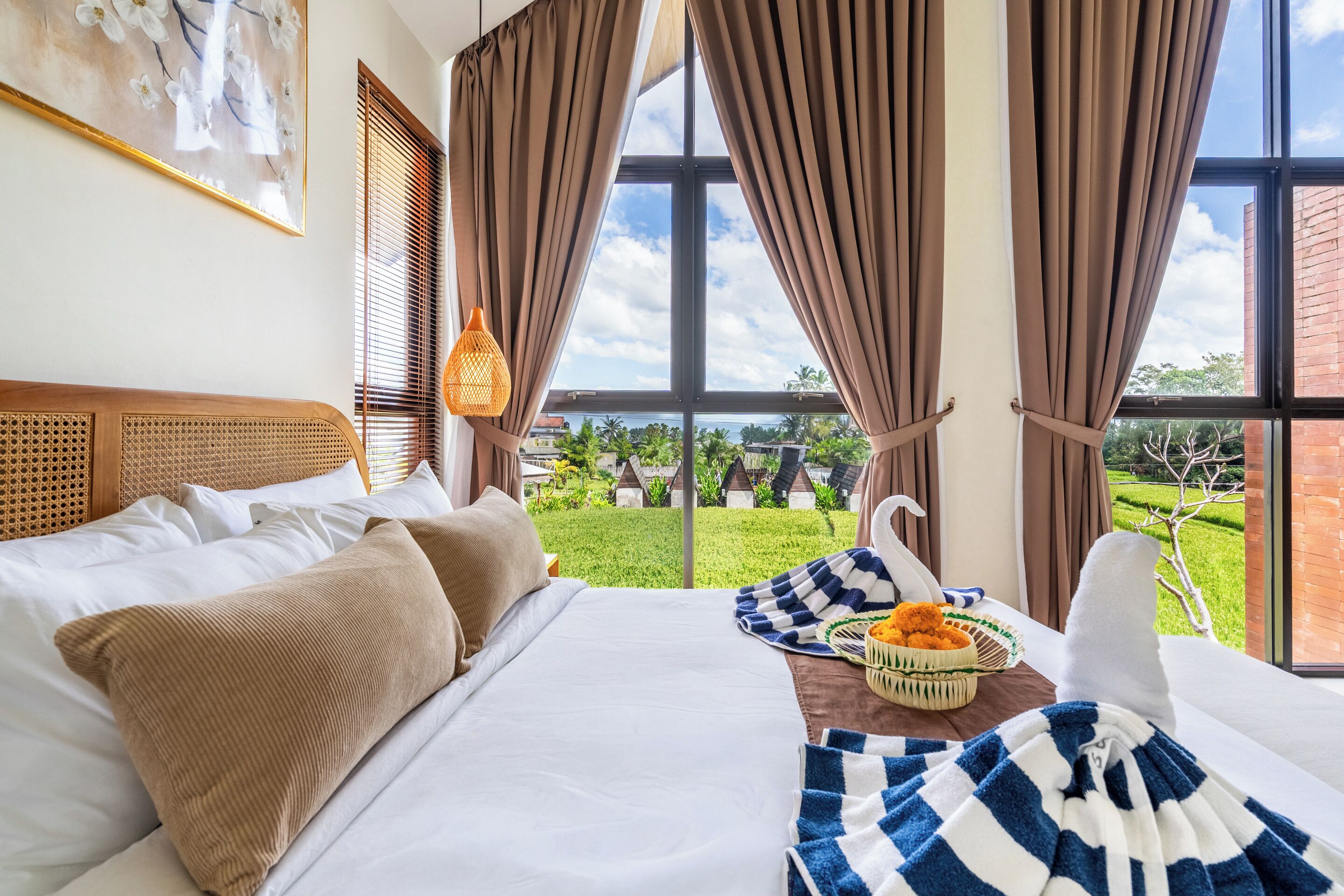 Habitación de hotel con una cama grande, vistas a un jardín y una bandeja de desayuno sobre la cama.
