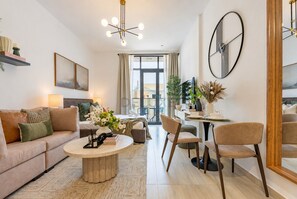 Ein modernes Wohnzimmer mit Sofa, Couchtisch und Essbereich.