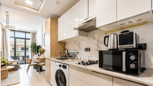 Eine moderne Küche mit Waschmaschine, Mikrowelle und Wasserkocher.