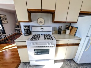 Eine Küche mit Herd, Kühlschrank und Holzschränken.