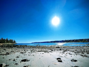 Ein Strand mit blauem Himmel und strahlender Sonne.