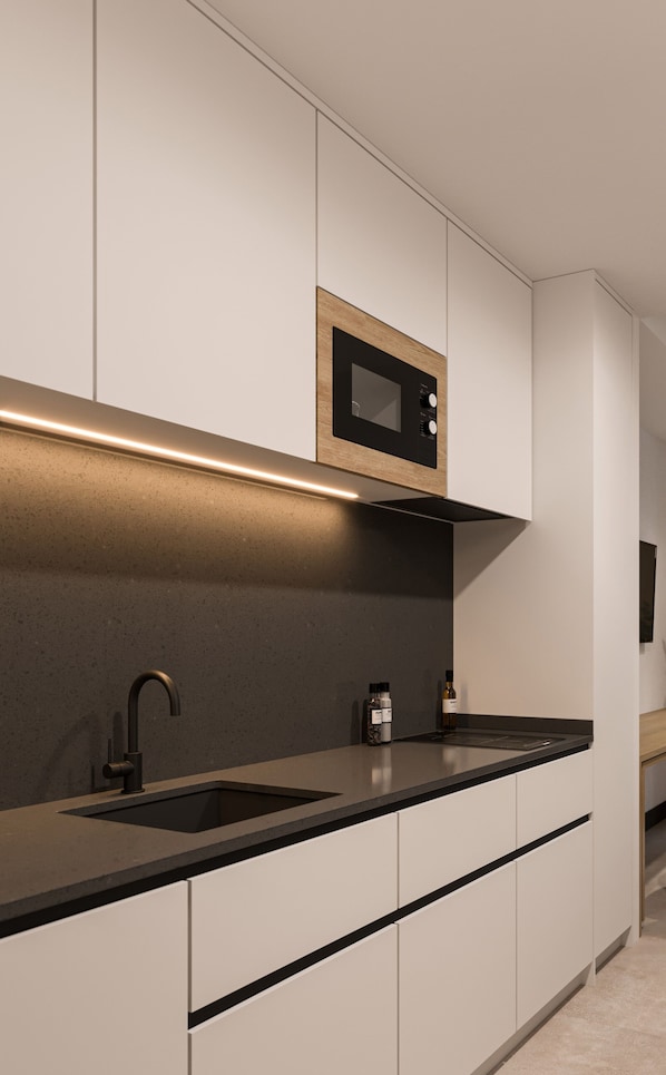 A modern kitchen with a built-in microwave, a sink, and a countertop.