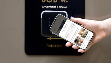 Een digitaal apparaat toont een incheckinterface van een hotel, met een smartphone in een hand.