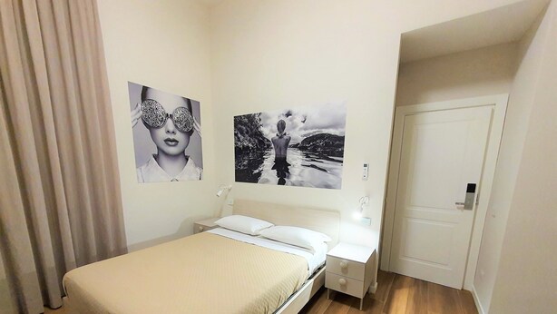 Een slaapkamer met een bed, nachtkastjes en wanddecoratie.