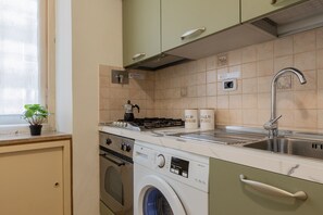 A compact kitchen with a stove, oven, washing machine, and sink. - Galliari Comfort Home by Wonderful Italy (Turin)